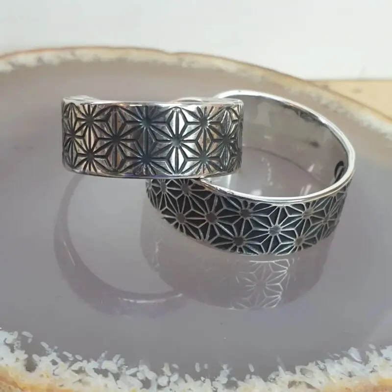 a pair of sterling silver wedding rings, etched with sacred geometry Asanoha pattern