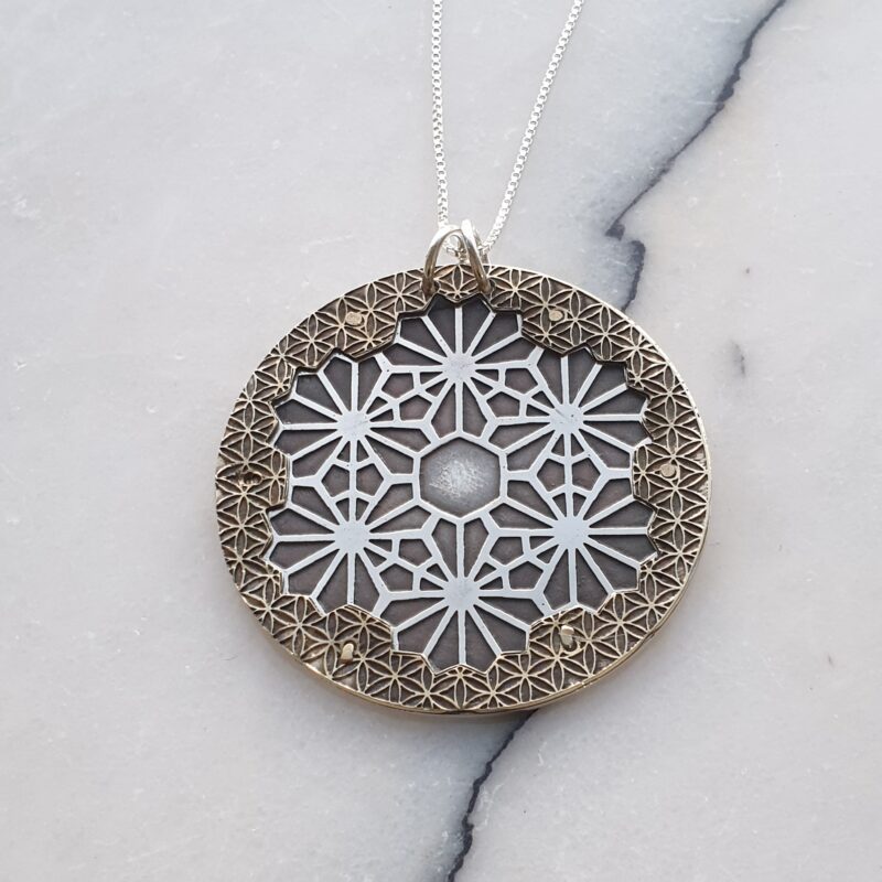Silver and brass pendant with etched geometric designs